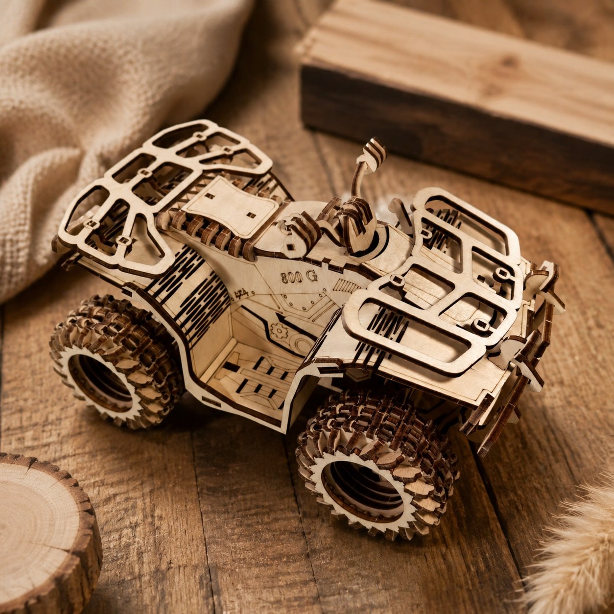 Close-up of the laser-cut wooden tires and grill on the ATV model.