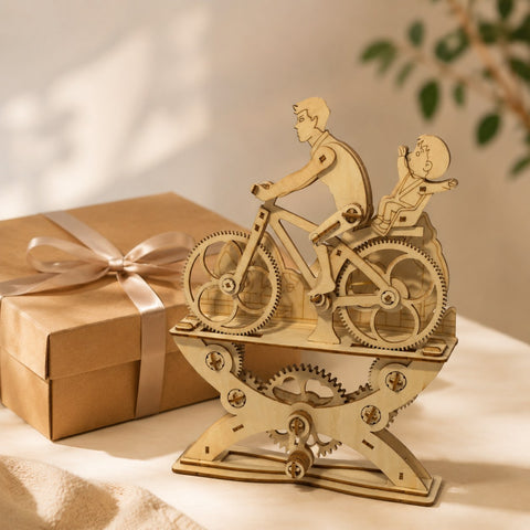 Wooden bicycle model next to a kraft gift box