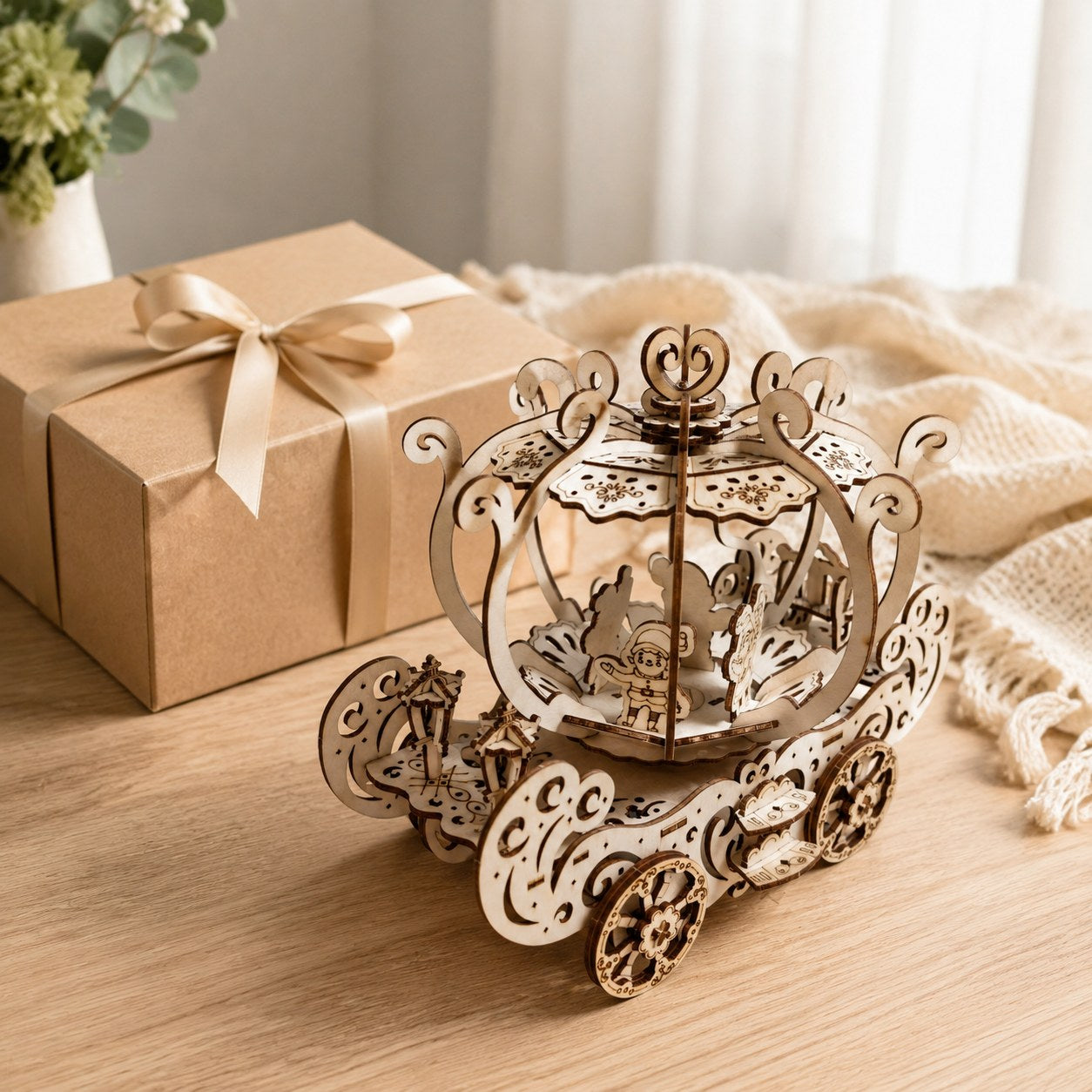 Wooden pumpkin carriage model next to a gift box
