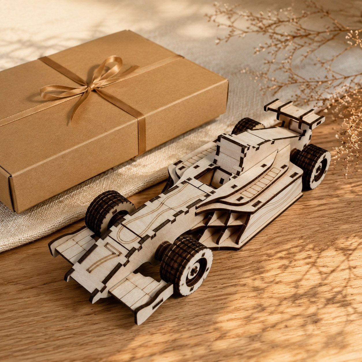 Wooden race car model displayed next to a gift box