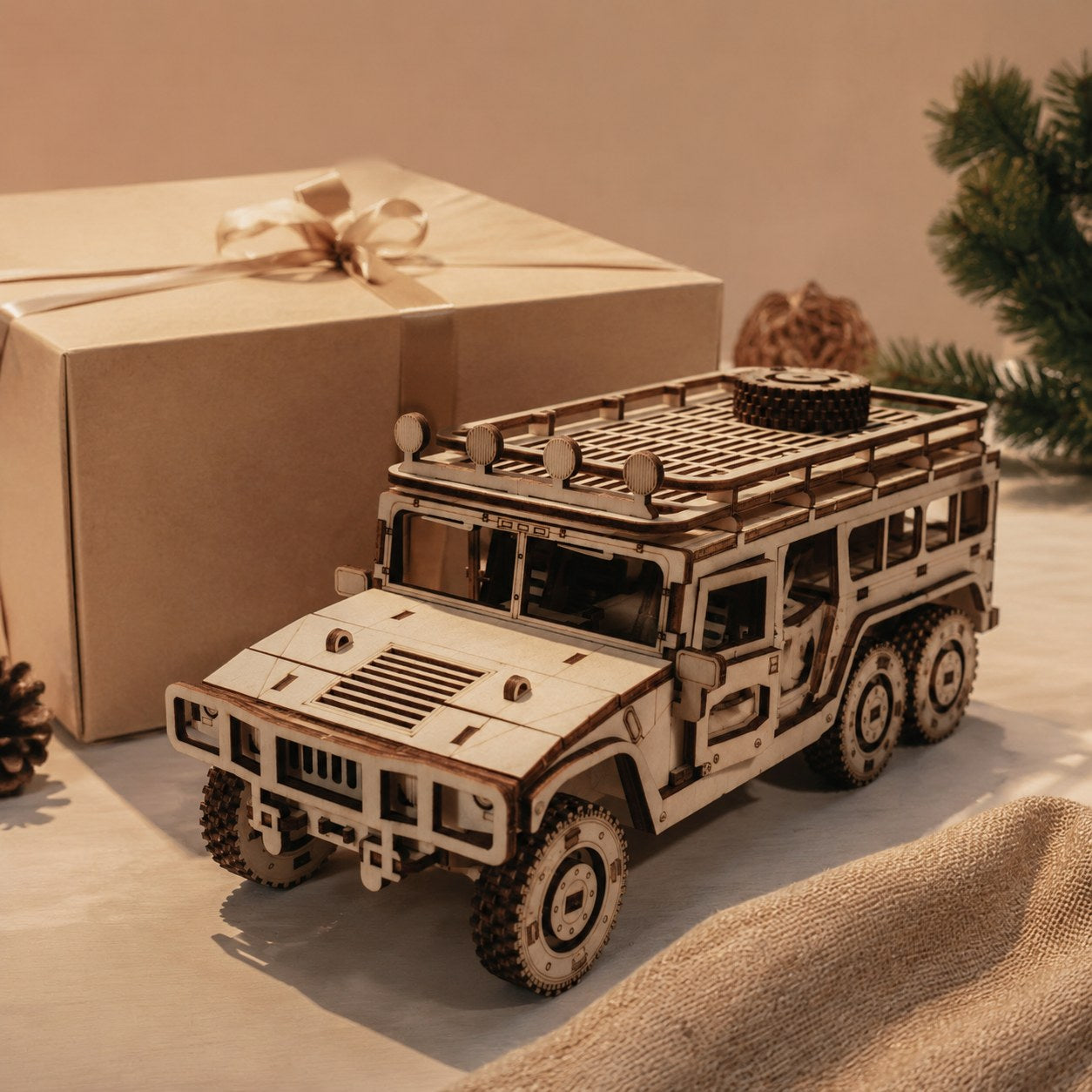 Finished 6x6 wooden truck model next to a kraft gift box