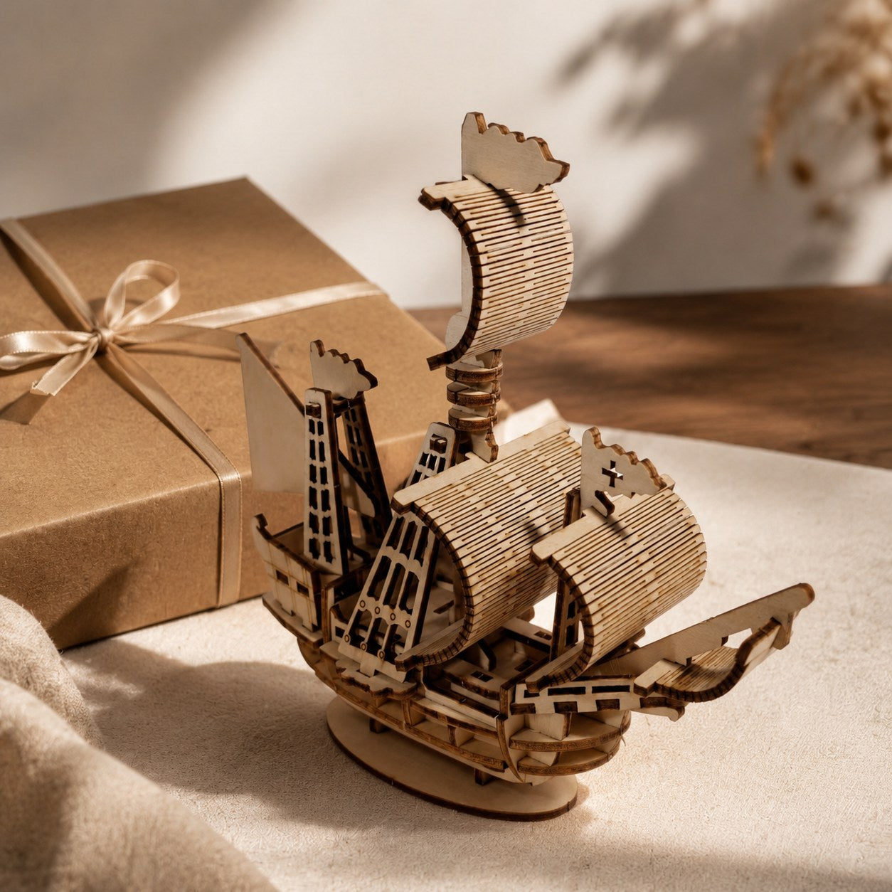 Wooden ship model next to a gift box