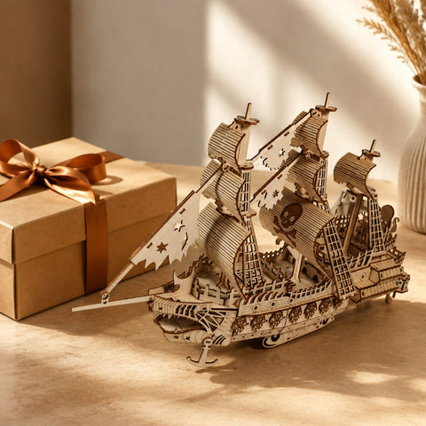 Wooden pirate ship model displayed next to a premium gift box