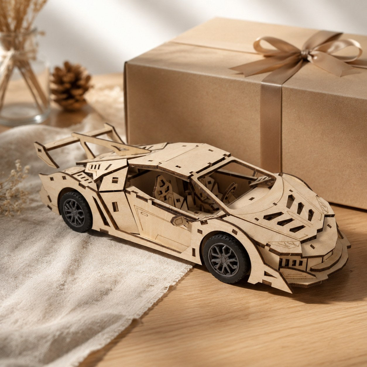 Wooden supercar model displayed next to a gift box