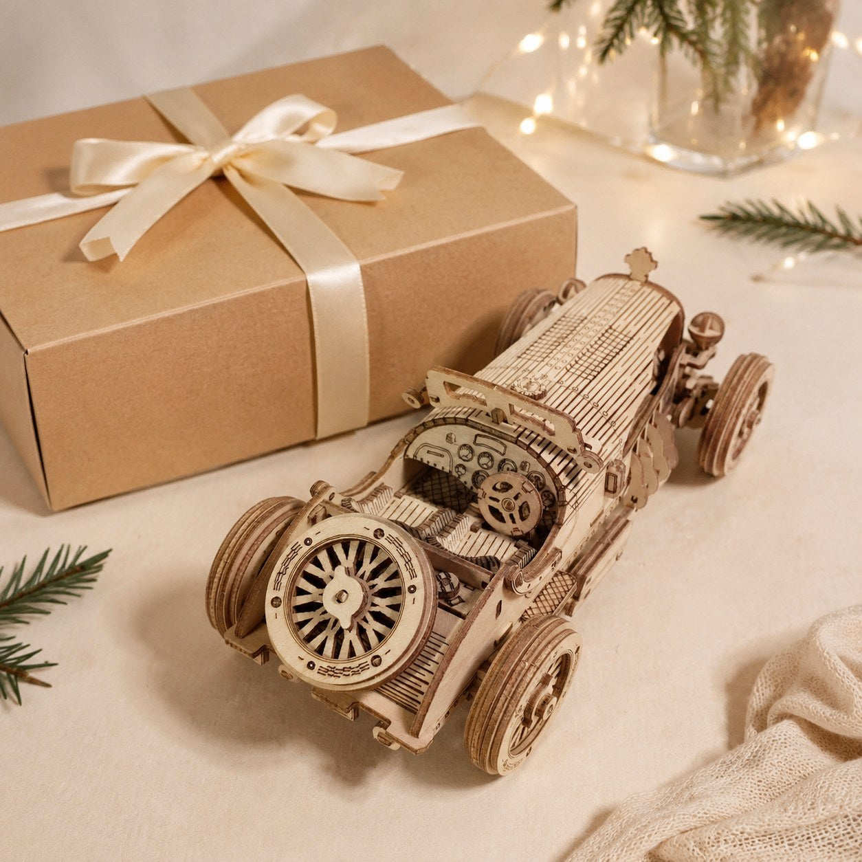 Finished vintage sports car 3D wooden puzzle displayed next to a wrapped kraft gift box.
