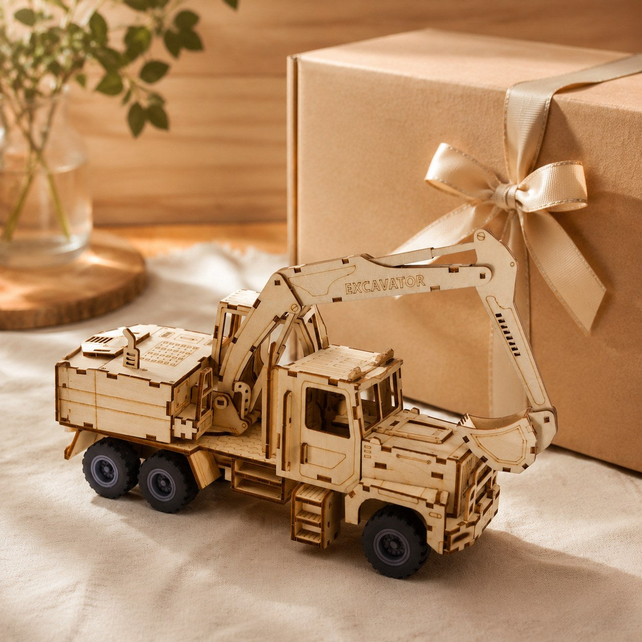Finished wooden excavator model next to a gift box