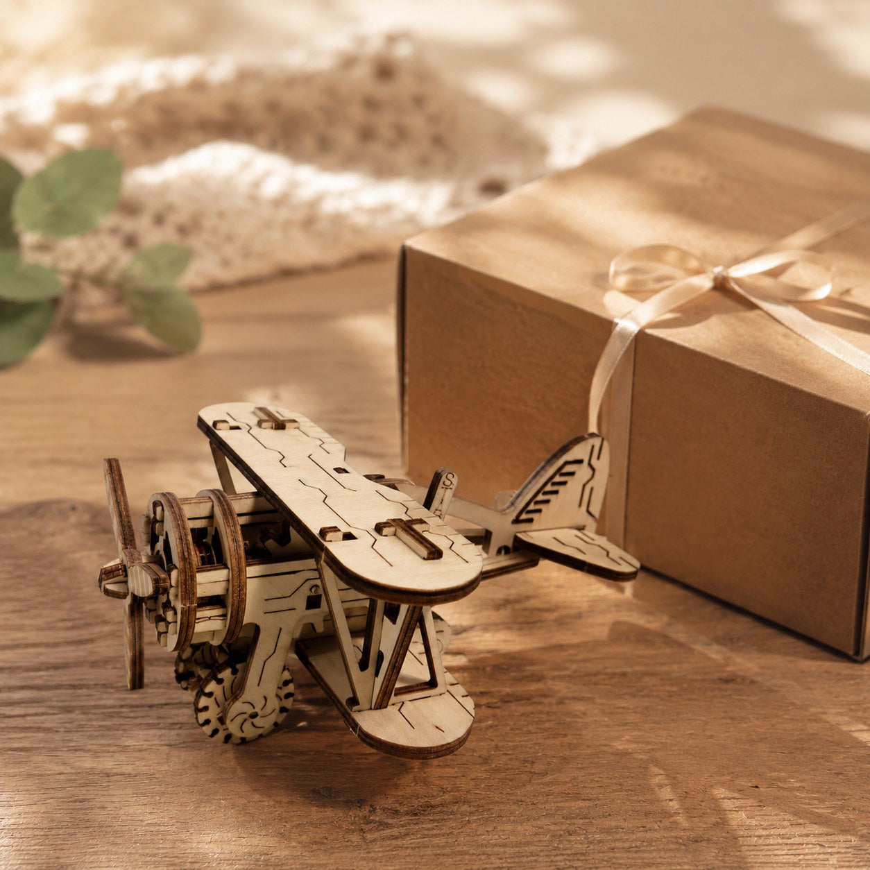 Finished wooden biplane puzzle displayed next to a gift box