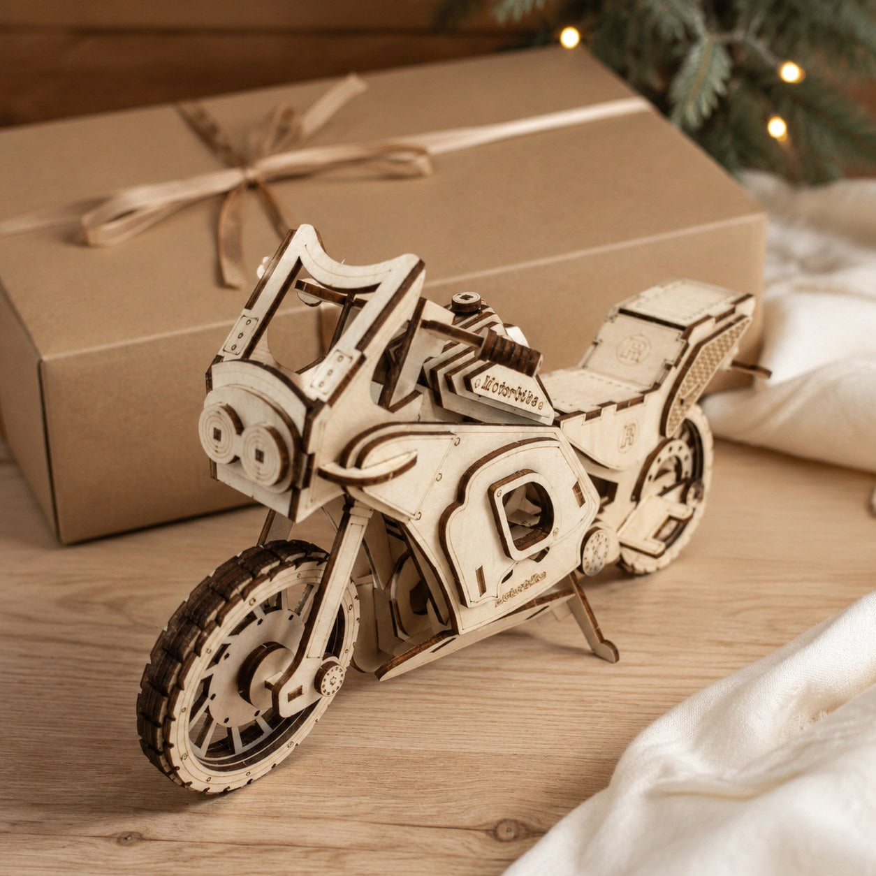 Wooden motorbike model displayed next to a kraft gift box