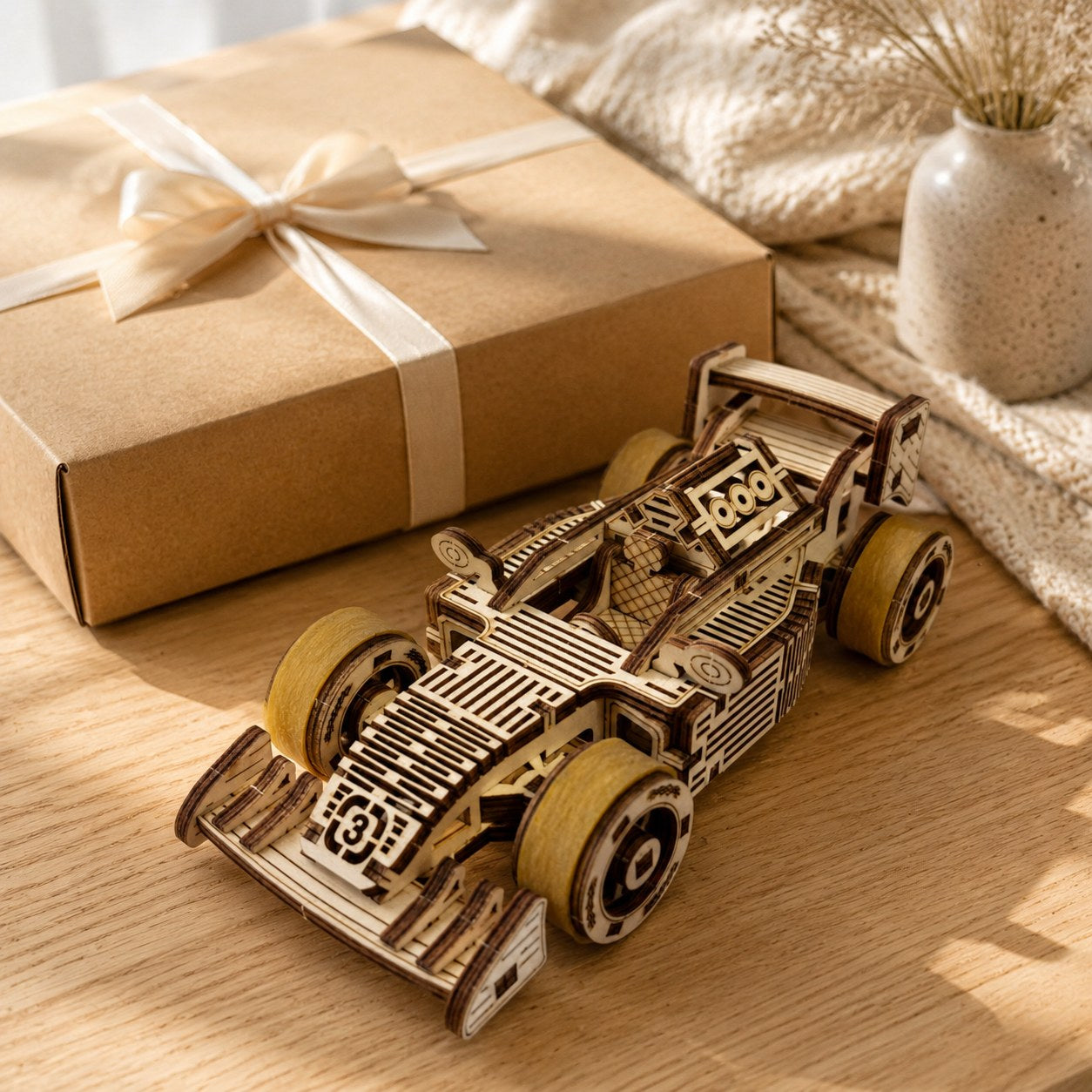 Wooden race car model next to a gift box